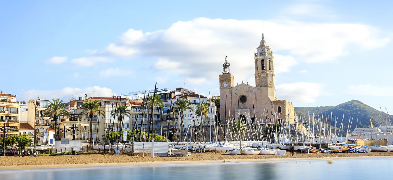 Where is Sitges located and what are the advantages of living there?